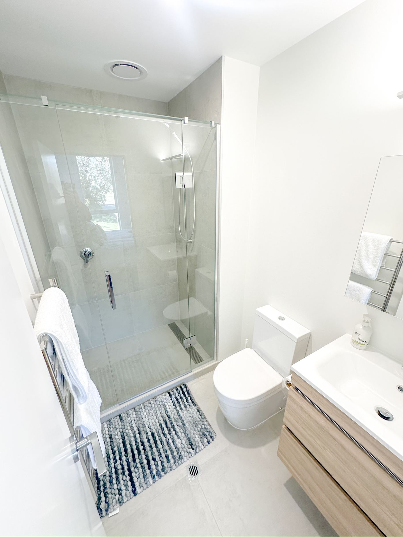 Bathroom with glass-walled shower and vanity